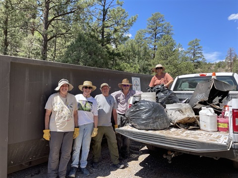 Aug 2023 Trail Clean-up Volunteers standing by a truckload of trash and cleaned-up materials