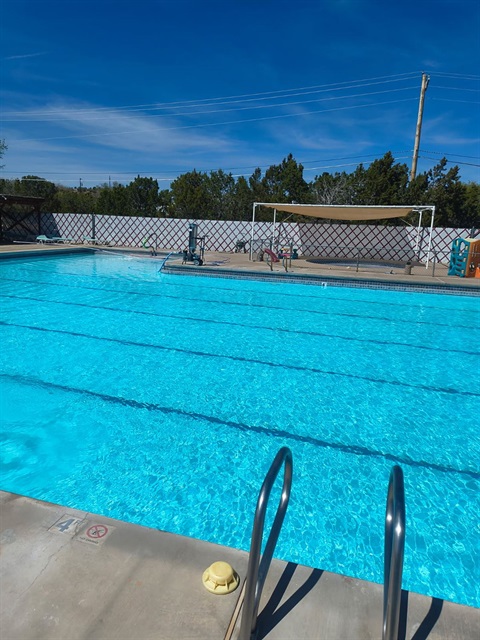 Picture of an outdoor pool, with a handrail, and shows swim lanes.