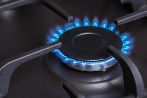 Blue natural gas flame on a gas stove burner