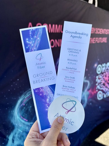 A bookmark with the order of events listed on the back and a sticker with the Atomic Fiber logo in it.