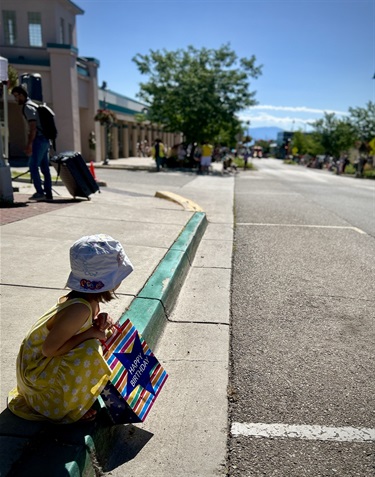 A young girl looks down Central Ave anticipating the County Fair parade
