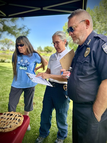 Fire Chief Wendy Servey and Police Chief Dino Sgambellone review pies at the Homemade Pie Contest.