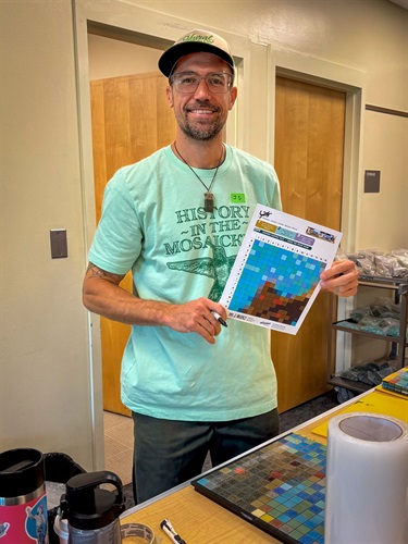 Photograph of mosaic artist J Muzacz smiling at the Mosaic Workshop.