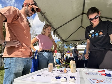 Photo of 3 adults playing the Department of Utilities game.