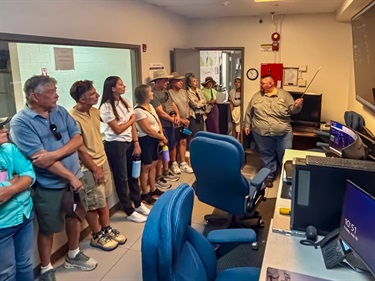 A tour group views the SCADA system with Water Systems Supervisor Victor Tanuz.