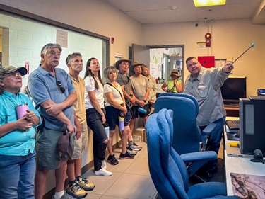 A tour group views the SCADA system with Water Systems Supervisor Victor Tanuz.
