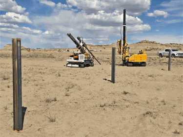 machinery pounding steel posts into ground