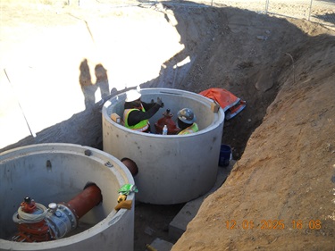 people installing pumps inside concrete housing