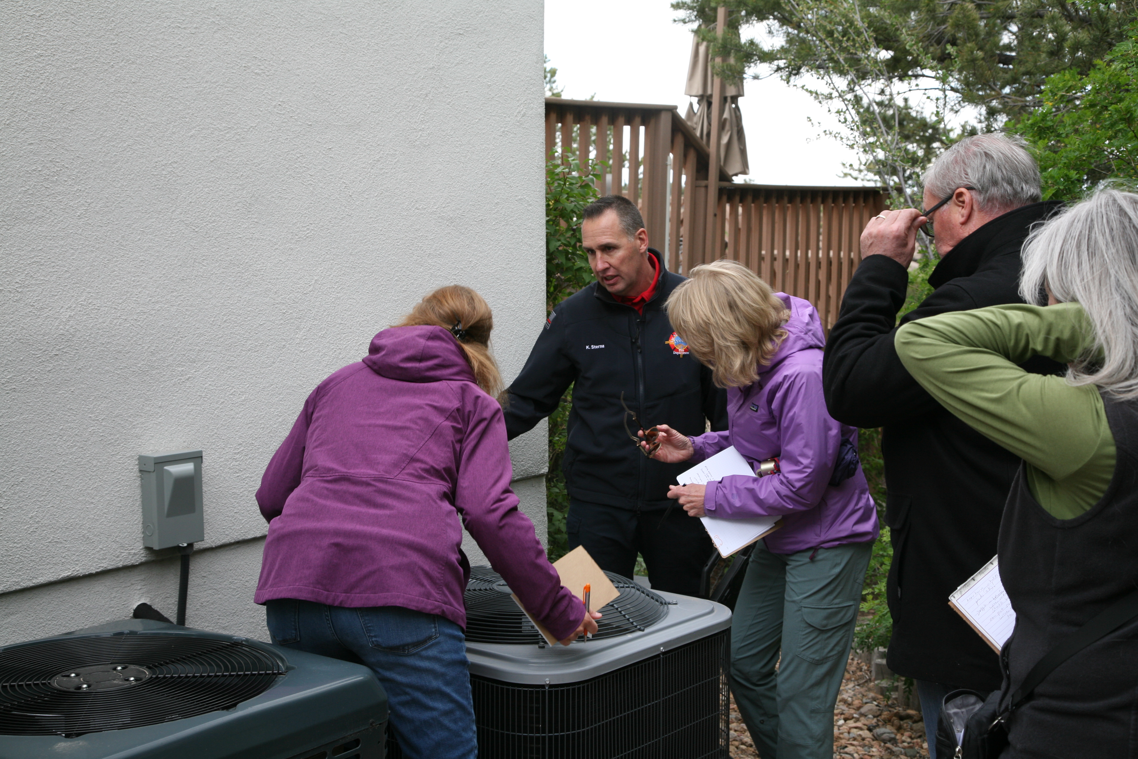 Former Wildland fire Chief Kelly Sterna conducts a home assessment while three homeowners look on