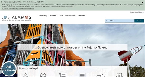 Screenshot of the new web design that has a white menu bar across the top, a photo of kids playing on a playground, and some buttons at the bottom.