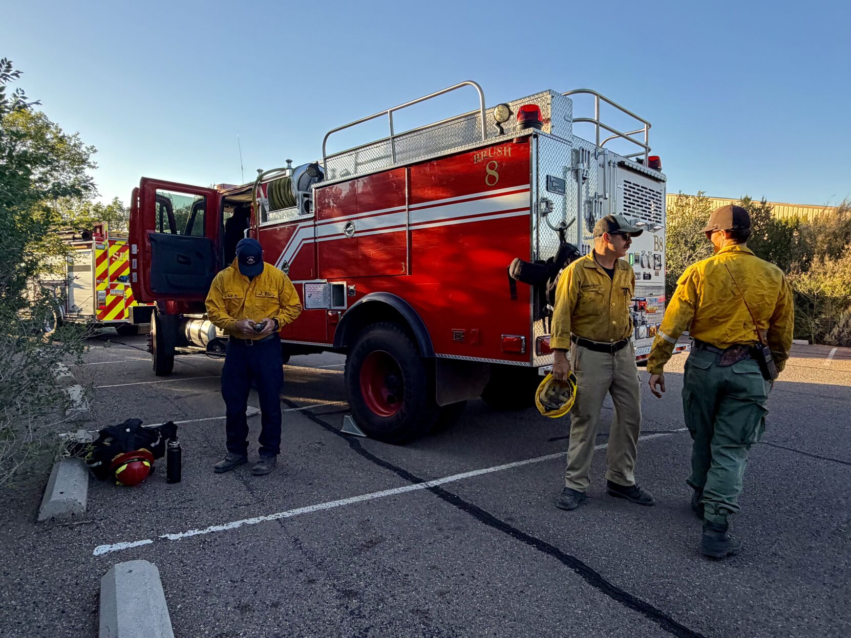 LAFD Brush 8 Captain John Bialy (left) and Firefighter Chad Drummond in the middle assisting with wildfire response north of Cañada de los Alamos, where multiple agencies worked together to contain a fire burning within the Santa Fe National Forest. by Nathan Burton. Copyright © 2026 The New Mexican, Inc. Reprinted with permission. All rights reserved.